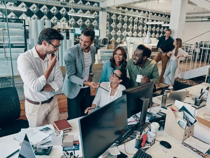 Group of young professionals collaborating and laughing during a meeting in a bright modern office on localservicemap.com